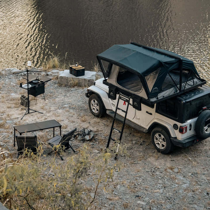 Jeep con tenda da tetto Wild Land aperta vicino a un fiume
