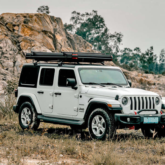 Jeep Wrangler bianca con tenda da tetto Wild Land chiusa su una pista in una cava