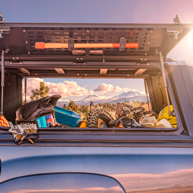 Toyota Hilux con hard top RSI SmartCap aperto e attrezzatura da viaggio nel cassone