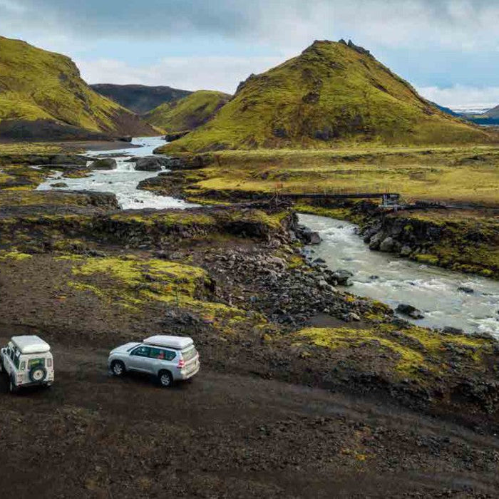 Due fuoristrada con tende da tetto Autohome chiuse su una pista sterrata lungo un fiume