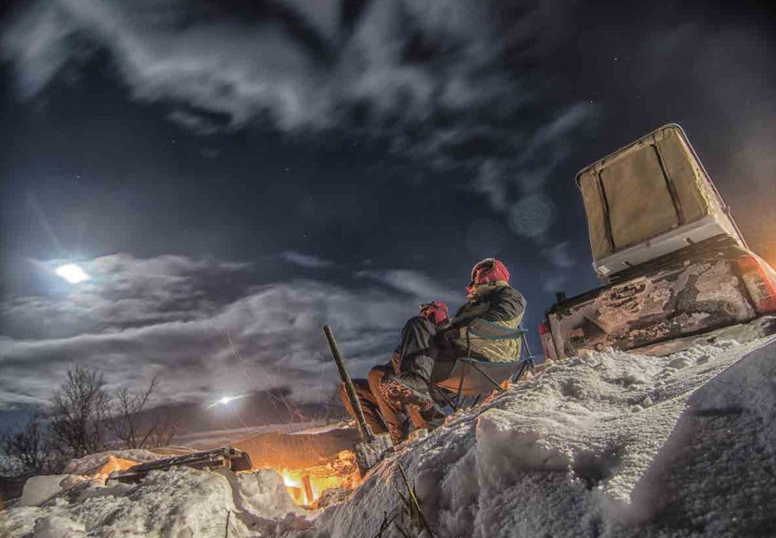 Fuoristrada con tende da tetto Autohome aperte di notte in un paesaggio innevato