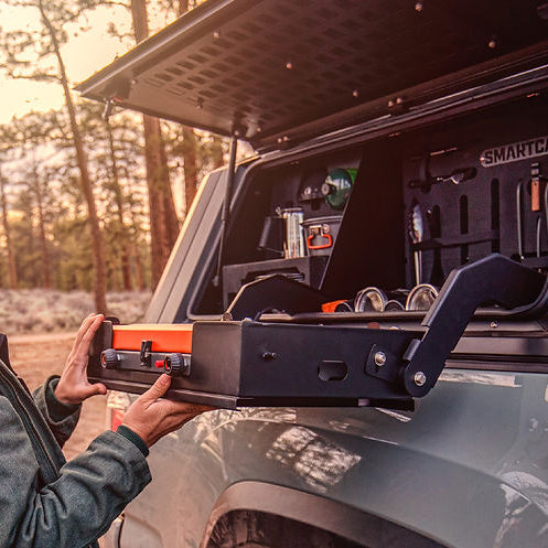 Donna che prepara il caffè alla cucina da campo laterale di un hard top su pick-up