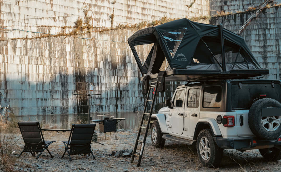 Jeep Wrangler con tenda da tetto Wild Land e campo tra le rocce