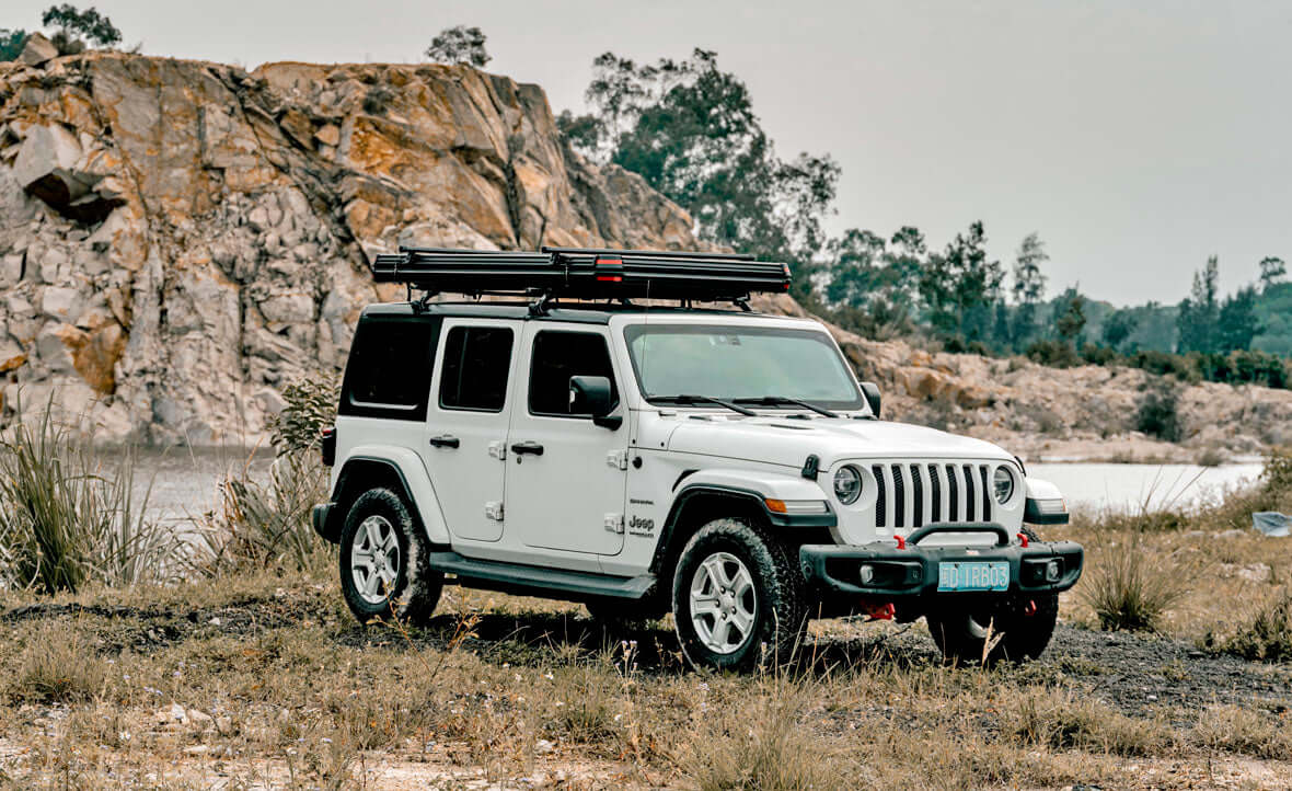 Jeep Wrangler bianca con tenda da tetto Wild Land chiusa su una pista in una cava