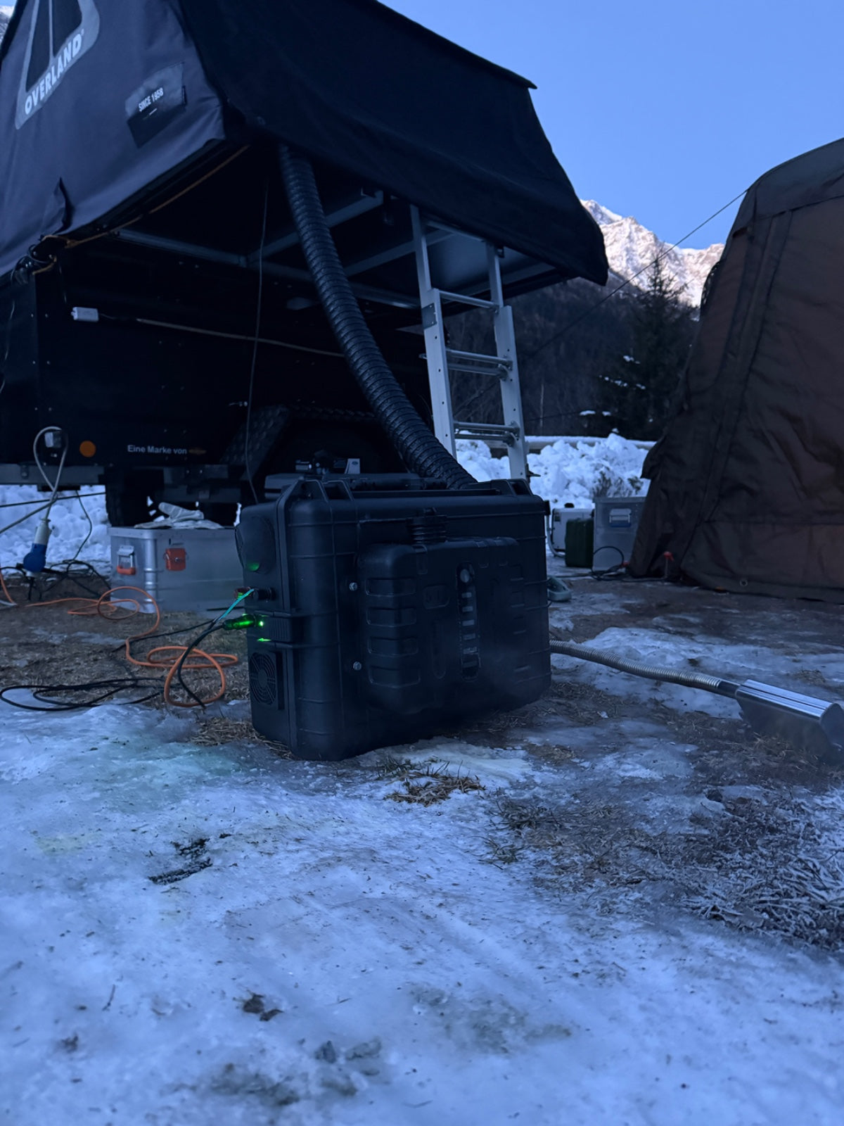 Valigetta del riscaldatore ARGOING OverlandHeat appoggiata sulla neve sotto una tenda