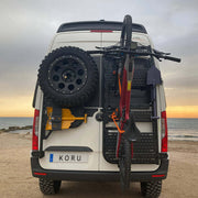 Supporto bicicletta basculante verticale montato su furgone Koru con ruota di scorta.