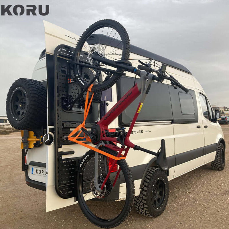 Supporto bicicletta basculante verticale installato su un furgone Koru con bici rossa e cerchi grandi.