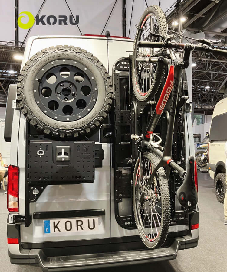 Supporto bicicletta basculante verticale Koru con ruota di scorta su furgone, ideale per trasporto bici.