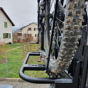 Supporto porta oggetti 40cm con bicicletta montata, vista laterale su struttura resistente in un paesaggio di campagna.