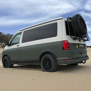 Supporto ruota Volkswagen T6 montato su furgone Koru Soluciones in un paesaggio sabbioso.
