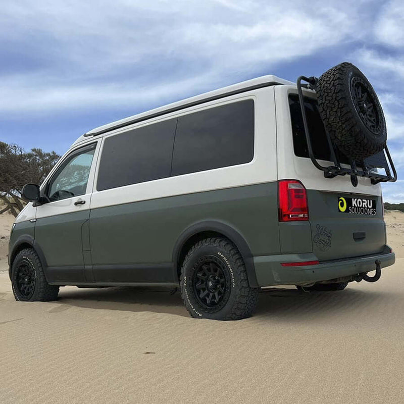Supporto ruota Volkswagen T6 montato su furgone Koru Soluciones in un paesaggio sabbioso.