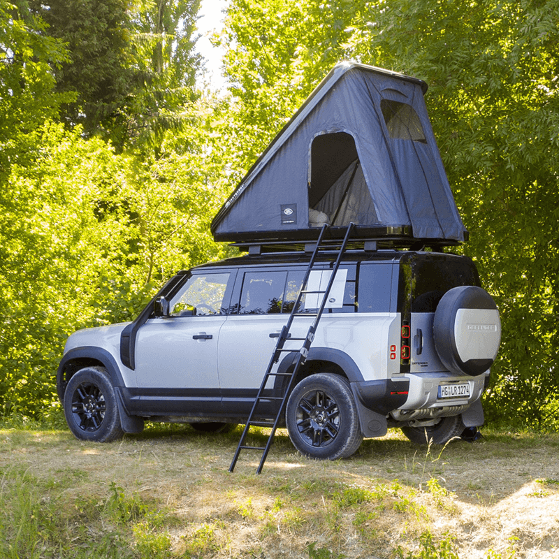 Land Rover Defender con tenda da tetto Autohome aperta e scala nel bosco