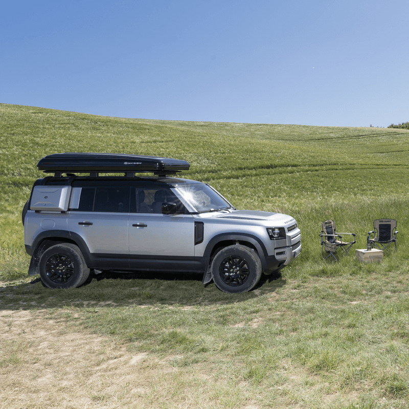 Defender con tenda da tetto Autohome chiusa e campo sul prato