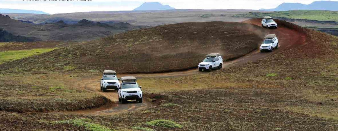 Colonna di SUV Land Rover Discovery con tende da tetto Autohome chiuse su una pista sterrata