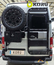 Supporto ruota posteriore regolabile montato su veicolo, dotato di accessori e ruota di scorta Koru.